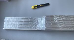 Unwrapping the shrink-wrapped aluminium extrusion lengths with a craft knife