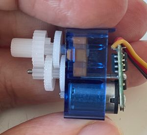 The SG90 servo with the gear chain visible. The final output gear is the one on the top left, which also couples into the potentiometer.