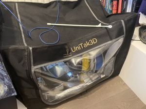 The Unitak 3D printer enclosure, sat on a shelf next to a row of robotics books