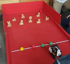 The Duck Shoot arena at Pi Wars 2018, with the robot lined up behind the balls
